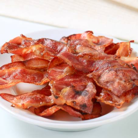 Single Crispy Bacon Strip on White Surface