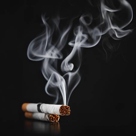 Smoking Cigarette with Smoke Rising Against Black Background