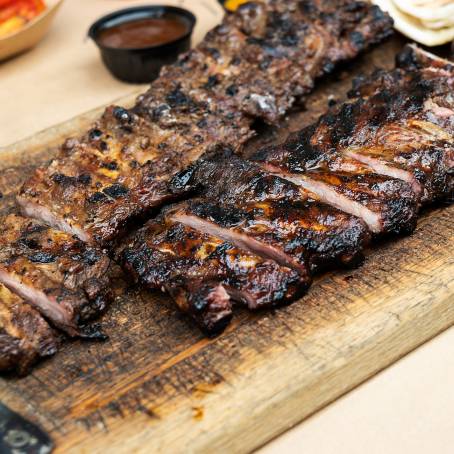 Succulent Grilled Ribs with Sweet and Smoky Barbecue Sauce on a Carving Board