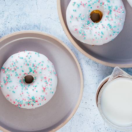 Sweet Strawberry Glazed Donuts with Festive Sprinkles on White Background