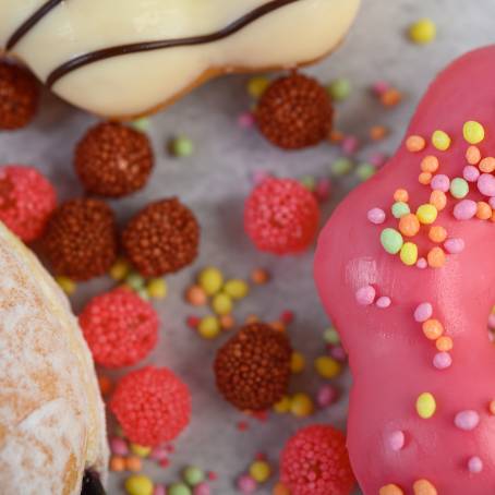 Sweet Strawberry Glazed Donuts with Rainbow Sprinkles on White Surface