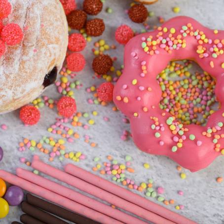 Tempting Strawberry Glazed Donuts with Sprinkles on Clean White Background