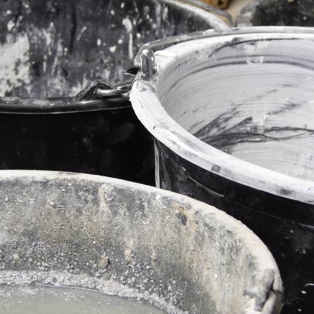 Three Metal Buckets in the Rain with Wet Surfaces