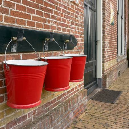 Three Metal Buckets Surrounded by Rain on a Cloudy Day