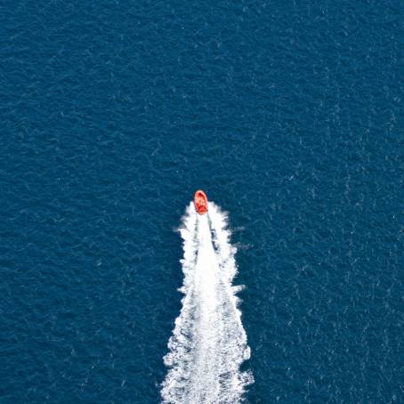 Top View of Boat Making Circular Waves and Bubbles