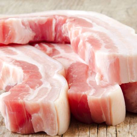 Top View of Raw Pork Belly Slices on Black Plate, Perfect for Recipes