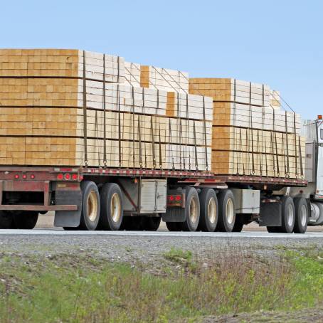 Truck Driving Through Curvy Road in Green Hills