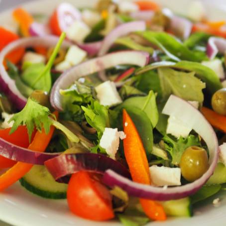 Vibrant Salad with Spinach, Cherry Tomatoes, Lettuce, Cucumber and Other Vegetables Isolated