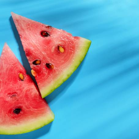 Vibrant Watermelon Slice on Blue Surface, Fresh Fruit, Summer Delight, Juicy and Refreshing