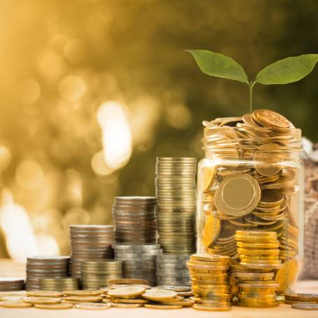 Visualizing Financial Growth Jar with Coins and Savings Concept on a Table