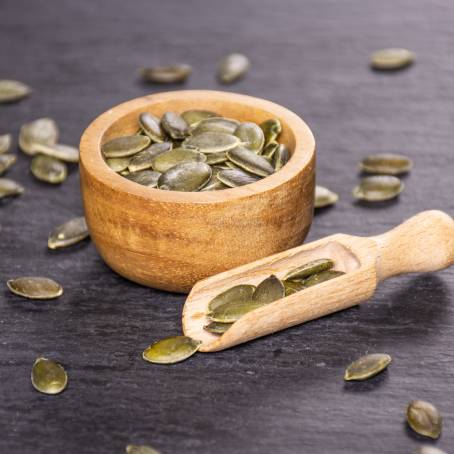 White Background Pile of Hulled Pumpkin Seeds for Healthy Eating