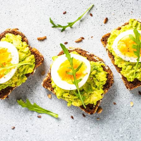 Whole Grain Toast with Soft Boiled Egg Halves and Dill, Healthy Breakfast on White Plate, Close Up